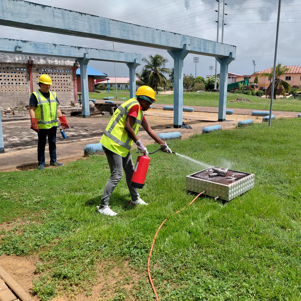 Cursist blust brand met blusser tijdens BHV-oefening in Paramaribo, NedCert Experts