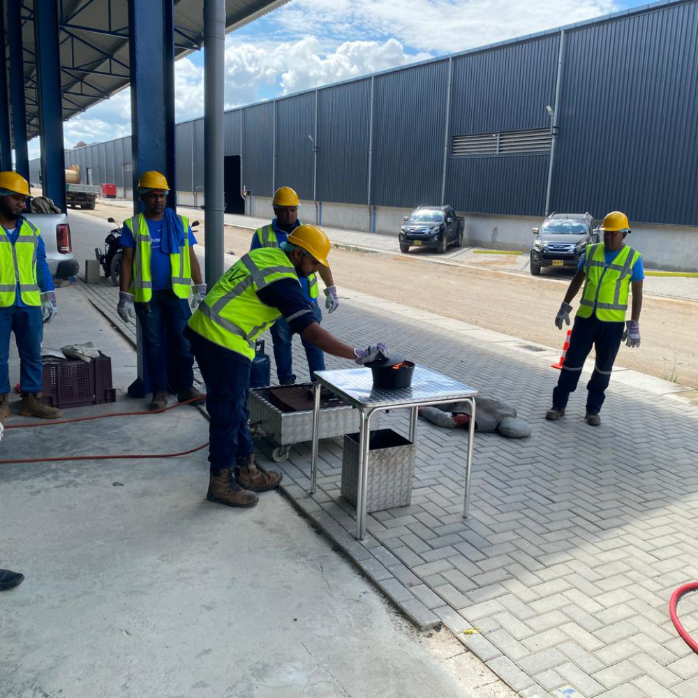 Cursisten blussen brand in de schaduw tijdens BHV-oefening in Paramaribo, NedCert Experts