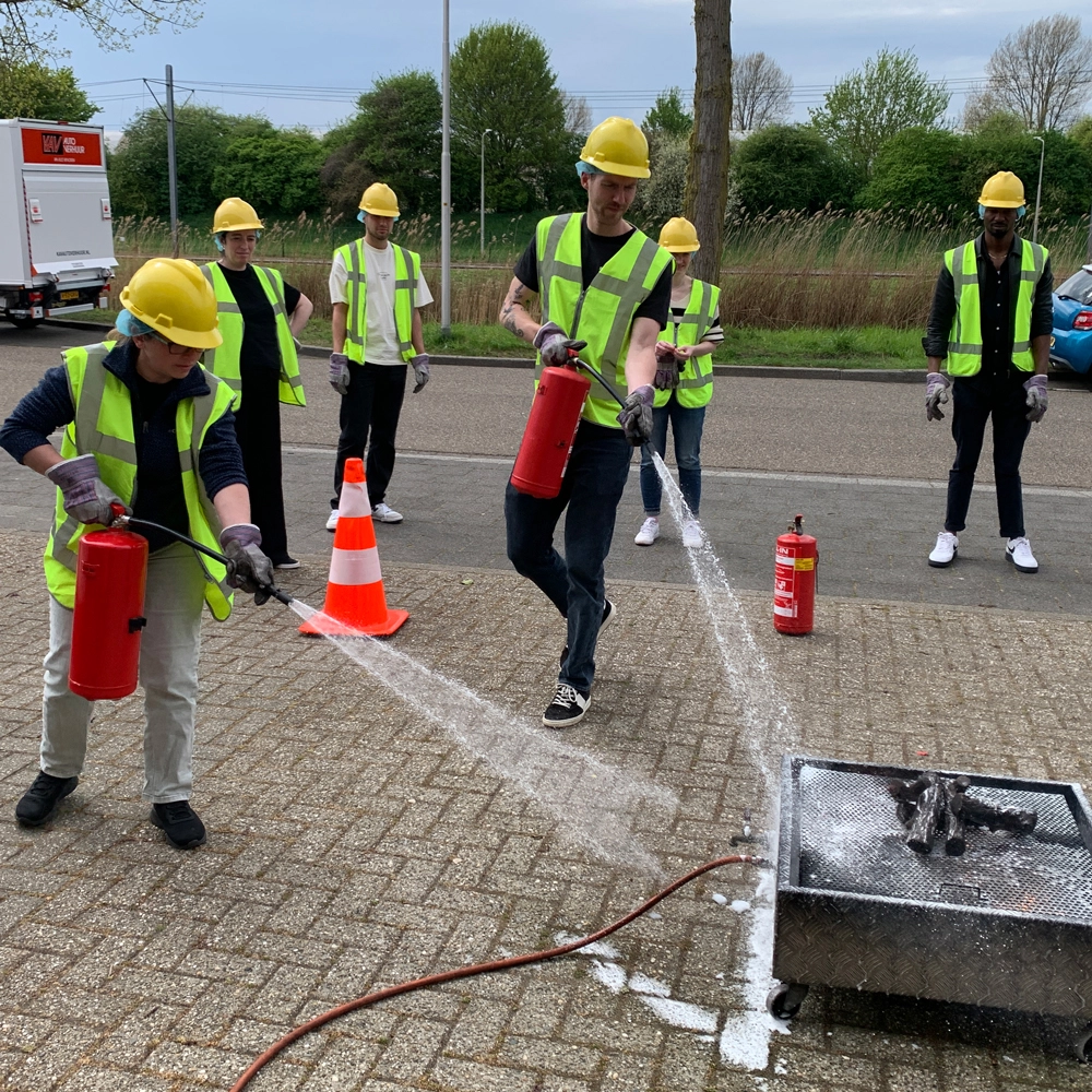 Cursisten blussen brand tijdens BHV-training in Amsterdam-Amstelveen, NedCert Experts.