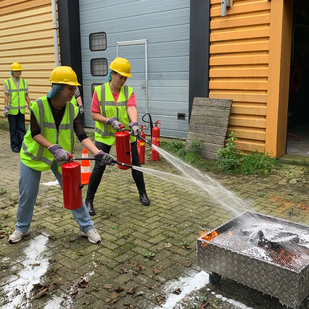 Cursisten blussen brand tijdens BHV-training in Leeuwarden, NedCert Experts.