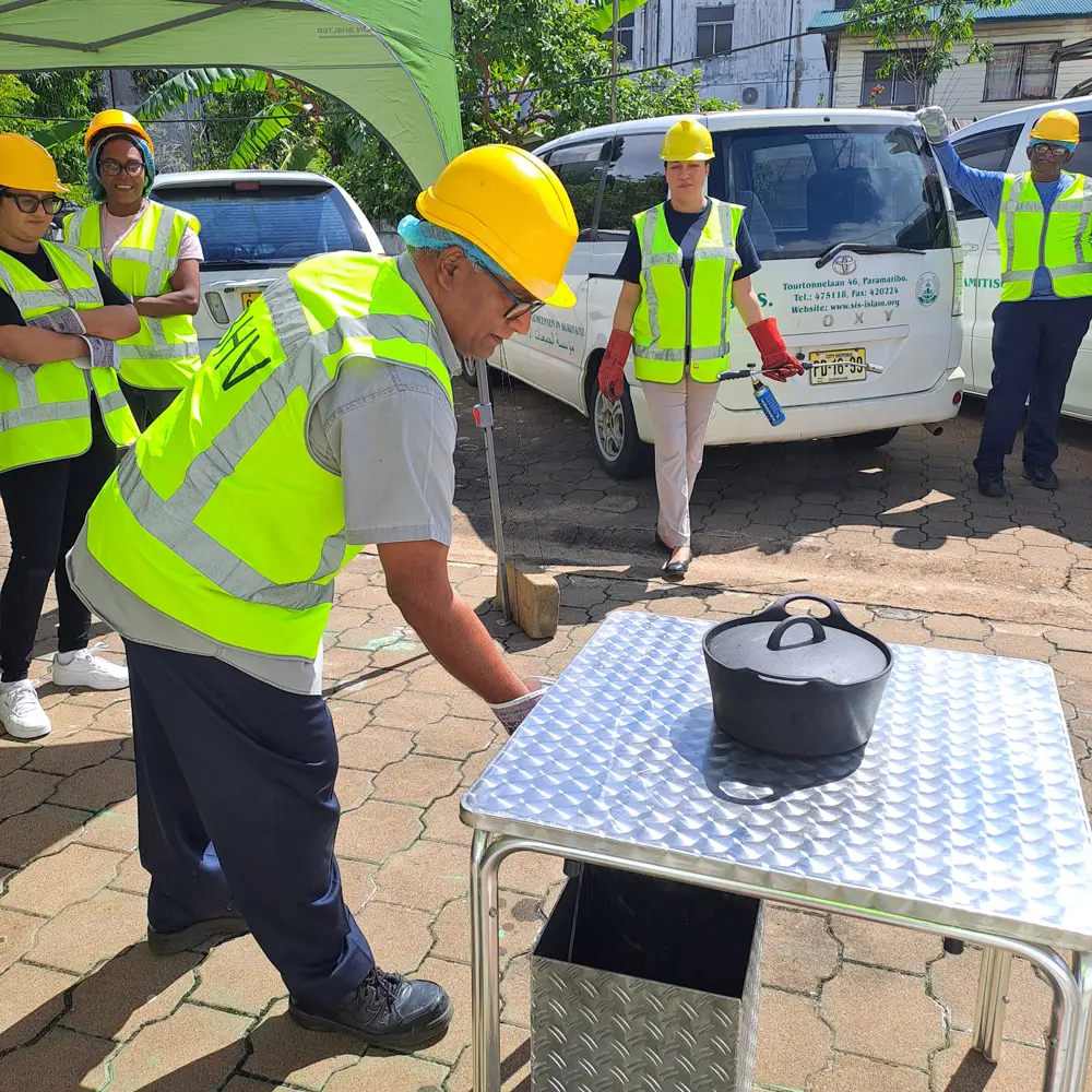 vlam in de pan blussen tijdens BHV-cursus op locatie BHV cursus Paramaribo NedCert