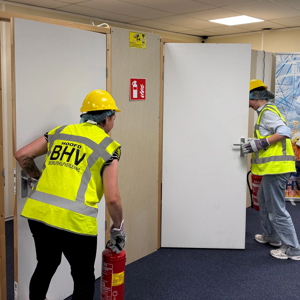Cursisten handelen bij ontruimingsoefening tijdens BHV-training, NedCert Experts.
