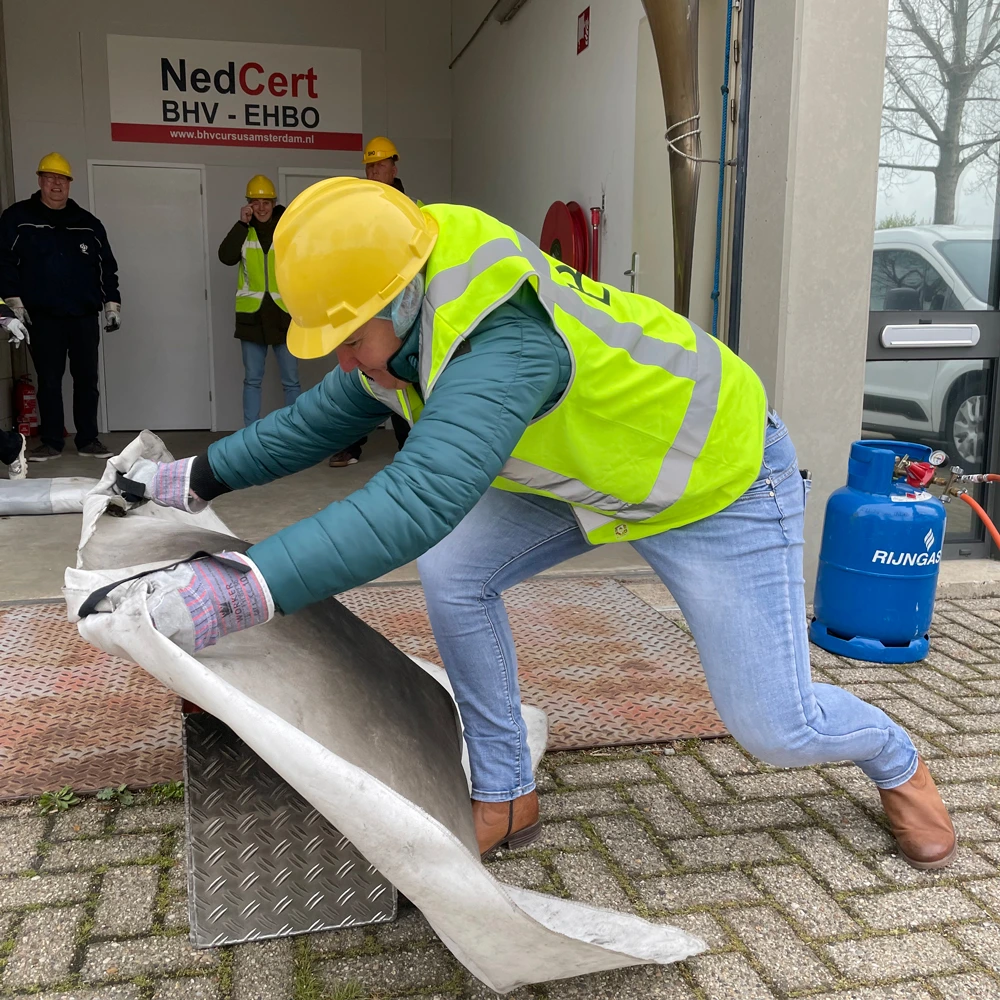 Instructeur gebruikt blusdeken bij prullenbakbrand-demo, NedCert Experts.