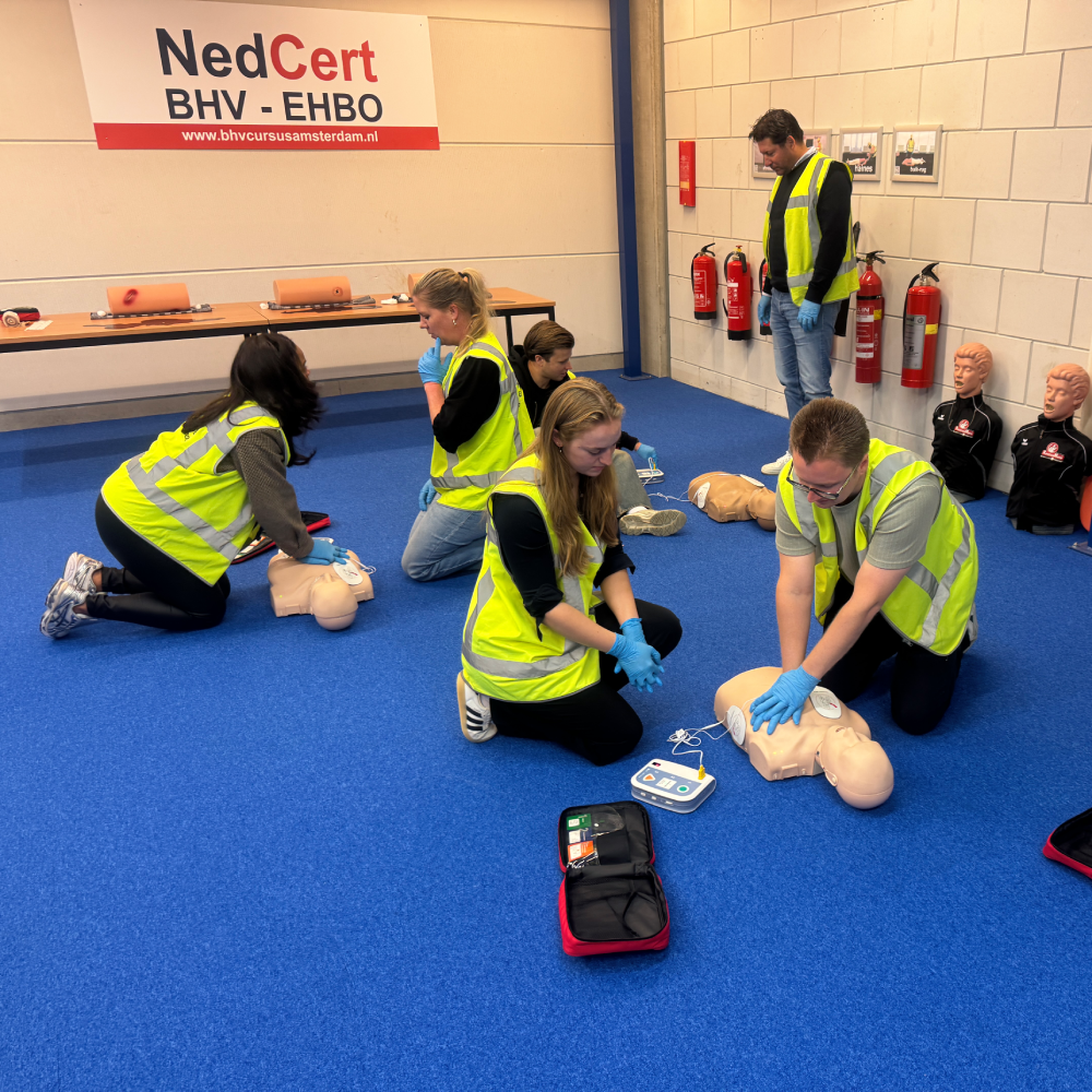 Groep cursisten oefent reanimatie met AED tijdens SHO-training, NedCert Experts