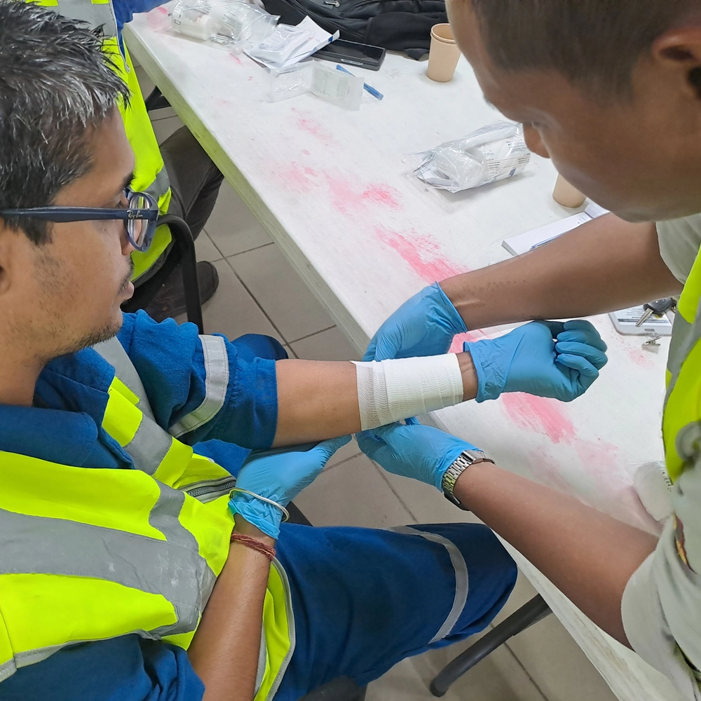 Cursisten oefenen verband aanleggen tijdens een BHV-training van NedCert Experts, een essentiële vaardigheid voor het gebruik van een traumakit in bedrijven.